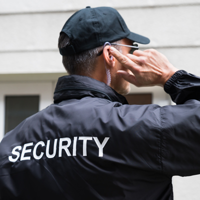 security personnel signaling with earpiece wearing black jacket